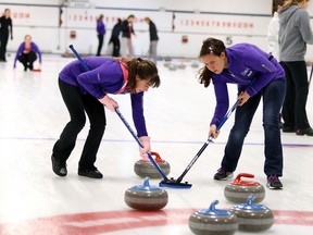 Macdonald Cartier girls curling team members, Manon Paquette and Julie Bourgoin sweep a shot from vice, Sophie Paquette to knock Marymounts rocks andout and steal the end during high school curling from the Sudbury Curling Club on Tuesday afternoon. Gino Donato/The Sudbury Star
