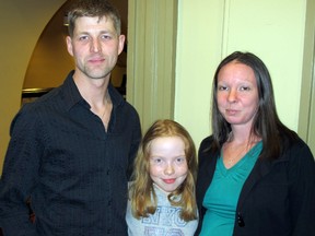 Kingston's Matt Henderson, seen here with Marissa Dunley, 8, and his girlfriend Christine Dunley, received an award from the City of Kingston Tuesday night for his actions in saving two co-workers during the blaze on Dec. 17, 2013, that destroyed a building that was being constructed at 663 Princess St.
Paul Schliesmann/TheWhig-Standard/QMI Agency