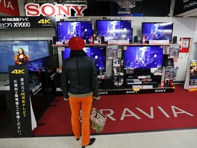 A woman looks at Sony's TV sets at an electronic shop in Tokyo, Jan. 17, 2013. REUTERS/Kim Kyung-Hoon