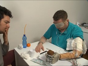Dennis Aabo Sorensen, right, is pictured in this YouTube screengrab using a LifeHand 2 prosthesis. (LifeHand 2/YouTube screengrab)