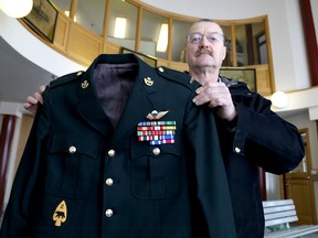 Dave Banks, president of the Kingston branch of the Princess Patricia's Canadian Light Infantry Association holds up a captain's uniform that was turned in by Carl Dale, who apologized for impersonating military members in Kingston.    
IAN MACALPINE/KINGSTON WHIG-STANDARD/QMI AGENCY
