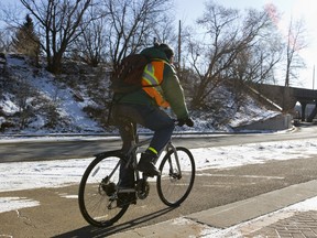 A cyclist rides down a bike lane past Ezio Faraone Park near the High Level Bridge in Edmonton, Alta., on Wednesday, Feb. 5, 2014. City council dealt with bike lanes and LRT fares at City Hall on Wednesday. Ian Kucerak/Edmonton Sun/QMI Agency
