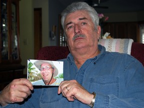 John Gall holds a photo of his son, the late Rick Gall, at his home in St. Thomas. Gall and his wife Denise are victims of an apparent fraud that bilked them out of $1,900 using information they believe was taken from Rick's obituary. Rick died Jan. 17 after a lengthy battle with cancer. Ben Forrest/Times-Journal