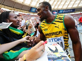 Usain Bolt of Jamaica greets a spectator as he celebrates winning the men's 4x100 metres relay final during the IAAF World Athletics Championships at the Luzhniki stadium in Moscow August 18, 2013. (REUTERS)