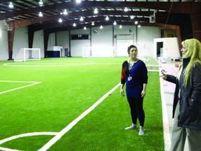 Jess Rheault, left, enjoys the feeling of the brand new artifical turf inside the Jaffray Melick Arena which will be open to the public to use after Friday, Feb. 7.
