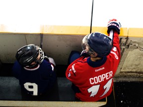 Taylor Cooper of the Lethbridge Hurricanes watches the play while a member of the Atom Chinooks watches him. Greg Cowan photo/QMI Agency.