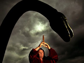 White witch Kevin Carlyon stands by a statue of the Loch Ness Monster as he performs an invocation on the banks of Loch Ness in an attempt to summon the Monster, June 13, 2003. (REUTERS)