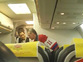 The man (R) who attempted to hijack an airliner from Ukraine is spoken to by flight attendants on February 7, 2014, after the plane was forced down in Istanbul. (AFP PHOTO/CIHAN NEWS AGENCY)