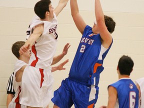 Chad Chessall of the Spartans puts the halt to this shot by a Morinville player during the opening game of the Top of the Rock tournament at St. Peter the Apostle school. The Spartans won this game 70-12. - Gord Montgomery, Reporter/Examiner