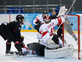 Canada's Rebecca Johnston (L) scores on Switzerland's goalie Florence Schelling during the second period
 of their women's ice hockey game at the 2014 Sochi Winter Olympics, February 8, 2014.