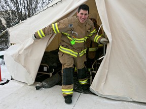 Firefighter Chris Fedor exits the tent he is staying in atop Fire Station 2 during the 2014 Rooftop Campout in Edmonton, Alta., on Monday, Feb. 3, 2014. The firefighters started the campout on Sunday and won't come down from the roof until Friday at 2 pm. Codie McLachlan/Edmonton Sun/QMI Agency