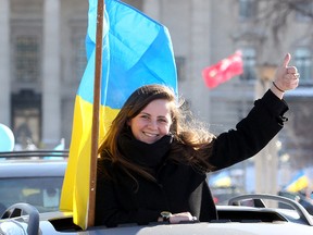 Daria Lytwyn waves from the roof of a car during the Auto-Maidan car rally in Winnipeg, Man. Sunday February 09, 2014 showing solidarity with the people of Ukraine. (Brian Donogh/Winnipeg Sun/QMI Agency)