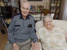Eric Stevens, 84, holds the hand of his 77-year-old wife, Dorothy, while she rests in his reclining chair on Feb. 7. The previous day, she fell while trying to get through the snow to collect their mail from the community mailbox.(Julia McKay The Whig-Standard)