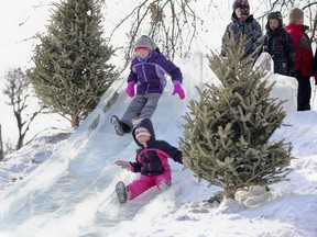 Sisters Abagail,10, and Emily Bakker, 6, take their turn down the big ice slide in Confederation Basin during the 10th annual FebFest on Saturday. (Julia McKay The Whig-Standard)