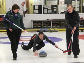 Mike Vosberg of Team Doremus throws a rock as his teammates Amanda Vosberg (right) and Michelle DeBuck get ready to sweep during the second end of the 1st Event Final at the 41st Oil-Chemical Bonspiel on Sunday, Feb. 9. Team Doremus, led by skip Chris Doremus won the match and the title in a 7-4 victory of Team Burdett. SHAUN BISSON/ THE OBSERVER/ QMI AGENCY
