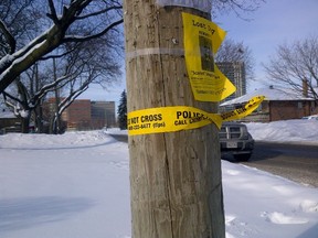 A piece of police tape wrapped around a pole at the intersection of Bisset
Ave. and Hargrove Lane in Etobicoke is all that remained Monday morning
after a man in his late 20s was shot to death the night before. (TERRY DAVIDSON/Toronto Sun)