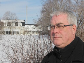 Clark Day stands in front of his 200-year-old home in Collins Bay with a newly-erected cellphone tower rising over it.
Michael Lea The Whig-Standard