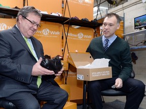 Minister of Finance Jim Flaherty, left, tries on a new pair of shoes during a pre-budget photo opportunity as Mellow Walk Footwear president Andrew Violi looks on in Toronto, February 7, 2014.  REUTERS/Aaron Harris