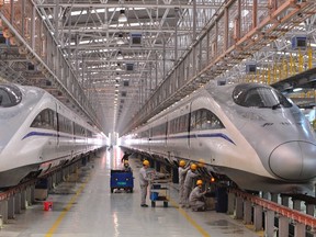 FILE PHOTO: Employees inspect a bullet train at a high speed railway maintenance station, Xinhua News Agency reported. REUTERS/Stringer