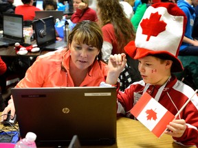 Clayton Spierman teaches his teacher, Kari Scott of Stoney Creek elementary school, a new software program that can write as he speaks during the At Quest conference held at the Thames Valley District school board education centre Monday. (MORRIS LAMONT, The London Free Press)