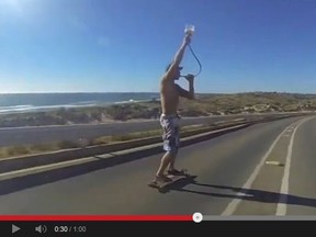 A skateboarder funnels beer as he cruises down a road. The drinking game has gone viral.