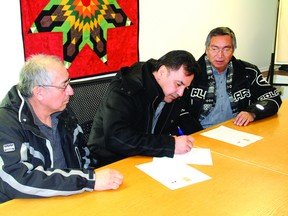 Chiefs (L–R) Howard Kabestra (Whitefish Bay), Leslie Cameron (Wabuaskang) and Simon Fobister (Grassy Narrows) sign a declaration on Monday, Feb. 10, requesting that the province transfer control of the logging operations inside the Whiskey Jack Forest to the First Nations.