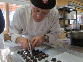 Peter Johner adds detail to a tray of Campari praline chocolates.
