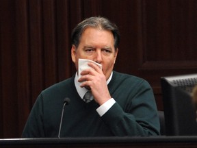 Defendant Michael Dunn, is shown in a television monitor as he reacts on the stand during testimony in his own defence during his murder trial in Duval County Courthouse in Jacksonville, Fla., on February 11, 2014. (REUTERS/Bob Mack/Pool)