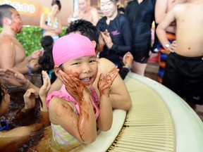 A girl dabs chocolate syrup on her body in a chocolate spa in Japan. (REUTERS FILE PHOTO)