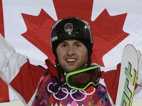 Canada's Alex Bilodeau celebrates on the podium at the men's freestyle skiing moguls at the Rosa Khutor Extreme Park during the Sochi Winter Olympics on February 10, 2014. (AFP PHOTO / FRANCK FIFE)