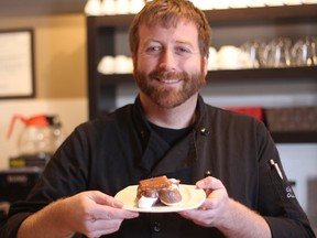 Matt Scanlan, owner of Forrat?s Chocolate Lounge in Byron, holds up a plate with a heated gourmet smore on it. The gourmet smores are among the most popular items at Forrat?s.