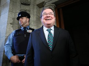 Finance Minister Jim Flaherty laughs while speaking with journalists in the foyer of the House of Commons on Parliament Hill in Ottawa January 28, 2014. REUTERS/Chris Wattie