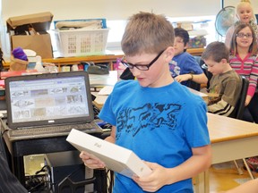 Drew Bechard is presented with an iPad at St. Joseph’s Catholic School Jan. 31. The Grade 4 student’s submission won out of 76 entries for Genworth’s Meaning of Home Contest which asked students to describe what the word “home” meant to them.
