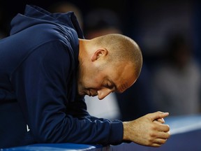 New York Yankees Derek Jeter puts his head down in the dugout as his team plays against the Toronto Blue Jays during their MLB American League baseball game in Toronto, September 17, 2013. (REUTERS/Mark Blinch)