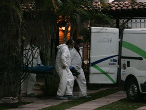 Forensic workers carry a body out of a house in Ajijic, near Guadalajara February 9, 2014. Police found the bodies of two Canadians after they were discovered by a gardener inside their house, after an apparent robbery, according to local media. REUTERS/Alejandro Acosta
