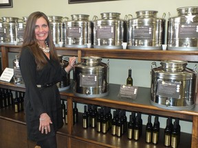 Missy Haggarty shows off some of the olive oil available at Olive-me * Co. The Hyde Park shop has dozens of choices of flavours for olive oil and balsamic vinegar.