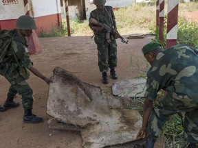 MISCA militaries cover the trap door of a petrol tank where several bodies lay in a former military camp, in Bangui, on February 13, 2014. (AFP PHOTO/FRED DUFOUR)