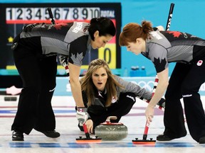 Canada's skip Jennifer Jones delivers a stone as second Jill Officer (left) and lead Dawn McEwen sweep during their women's curling round robin game against Denmark at the Sochi 2014 Winter Olympic Games, Feb. 13, 2014. (INTS KALNINS/Reuters)