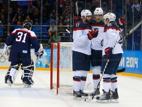 Team USA's Phil Kessel (81) reacts with teammates Ryan Kesler (17) and James van Riemsdyk after scoring on Slovakia's goalie Jaroslav Halak (L) during the second period of their men's preliminary round ice hockey game at the 2014 Sochi Winter Olympics on Feb. 13, 2014. (REUTERS/Brian Snyder)