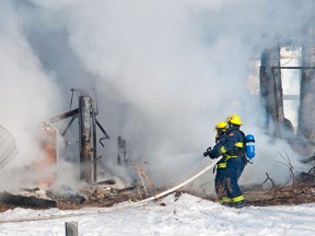 Crews battle to keep a garage fire contained west of Pincher Creek on Tuesday, Feb. 11 2014. Bryan Passifiume photo/QMI Agency