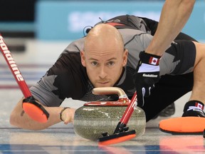 Canada's Ryan Fry throws a stone during a men's curling round robin session at the Ice Cube Curling Center during the Sochi Winter Olympics on February 14, 2014.  (AFP PHOTO / DAMIEN MEYER)
