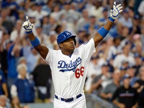 Los Angeles Dodgers outfielder Yasiel Puig reacts after hitting an RBI triple against the St. Louis Cardinals in Game 3 of the National League Championship Series at Dodger Stadium in Los Angeles October 14, 2013. (Richard Mackson/USA TODAY Sports)