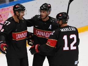 Canada's Jeff Carter (77) celebrates his third goal in the second period to complete a natural hat trick against Austria with teammates Jonathan Toews and Patrick Marleau during their men's preliminary round ice hockey game at the 2014 Sochi Winter Olympics, February 14, 2014. (REUTERS)