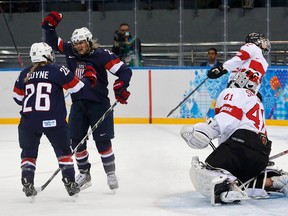 Team USA's Amanda Kessel (centre) reacts with teammate Kendall Coyne after scoring on Switzerland's goalie Florence Schelling during their women's preliminary round hockey game at the Sochi 2014 Winter Olympic Games, Feb. 10, 2014. (MARK BLINCH/Reuters)