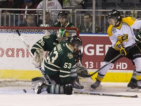 London Knights goaltender Jake Patterson keeps his eye on a shot by Sarnia Sting forward Noah Bushnell as Knights forward Bo Horvat attempts to block the shot during their OHL game at Budweiser Gardens in London, Ontario on Friday, February 14, 2014. (CRAIG GLOVER, The London Free Press)