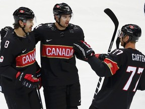 Canada's Drew Doughty (L) celebrates his goal against Austria with teammates Marc-Edouard Vlasic (44) and Jeff Carter (77) in the first period of their men's preliminary round ice hockey game at the 2014 Sochi Winter Olympics, February 14, 2014. (REUTERS/Jim Young)
