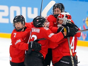 Switzerland's Lara Stalder (7), Sandra Thalmann (92), Laura Benz and goalie Florence Schelling (L-R) celebrate after defeating Russia in their women's ice hockey quarter-final play-off game at the 2014 Sochi Winter Olympics February 15, 2014.  (REUTERS)