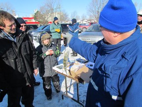 Al Dezort, right, with the Bluewater Anglers weighs a perch caught by Robert Mclachlen of Sarnia at the ice fishing derby Saturday on Sarnia Bay. The fish weighed in at 0.52 kg and earned Mclachlen top prize. PAUL MORDEN/THE OBSERVER/QMI AGENCY