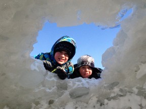 Welland, Ont., brothers Landon and Harrison Hollingsworth look into one of the ice caves that has formed on the Lake Erie shoreline near Crystal Beach Saturday. (DAN DAKIN/QMI Agency)