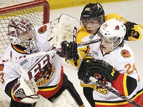 Belleville Bulls goalie Michael Giugovaz and defenceman Alex Yuill battle with Kingston Frontenacs forward Spencer Watson during OHL contest Monday afternoon in Kingston. (ELLIOT FERGUSON/Kingston Whig Standard)